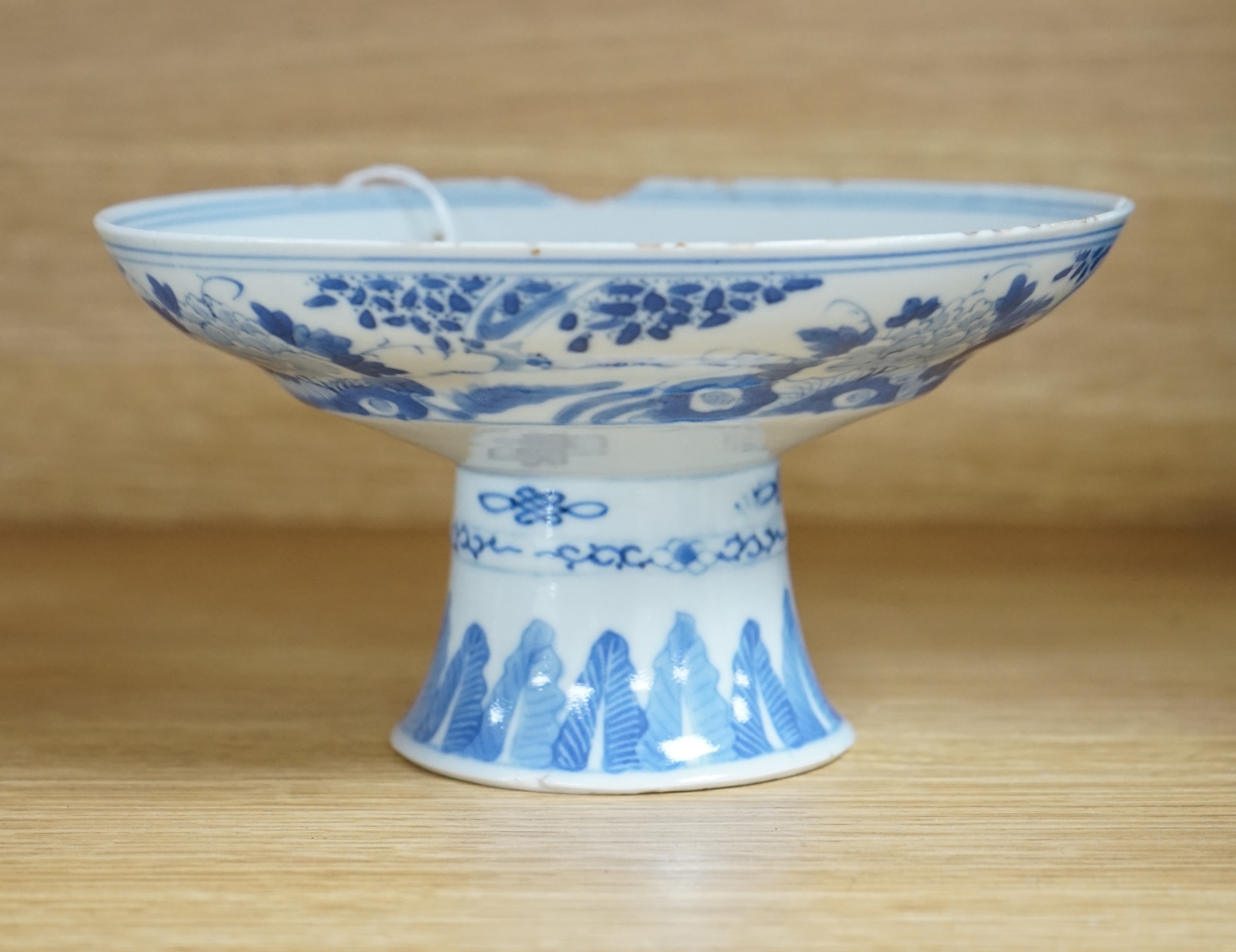 A Chinese blue and white stem dish, Kangxi mark, c.1900. Condition - poor to fair, some significant chipping to rim